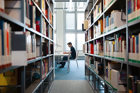 [Translate to Englisch:] Blick in einen Gang der Bibliothek am Campus Wilhelminenhof