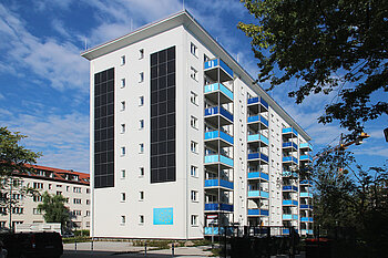 Mehrstöckiges Wohnhaus aus den 50er Jahren mit blauen Balkons